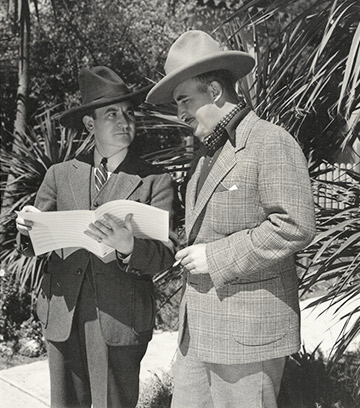 Photo of M.K. Jerome, and his lyricist partner Jack Scholl working on music for westerns in the 1930s